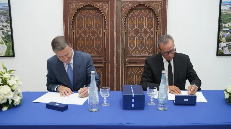 UNE President James Herbert and President Bouchta El Moumni of Abdelmalek Essaadi University sign an agreement at a formal table